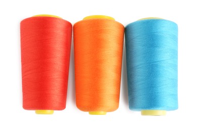 Colorful sewing threads on white background, top view