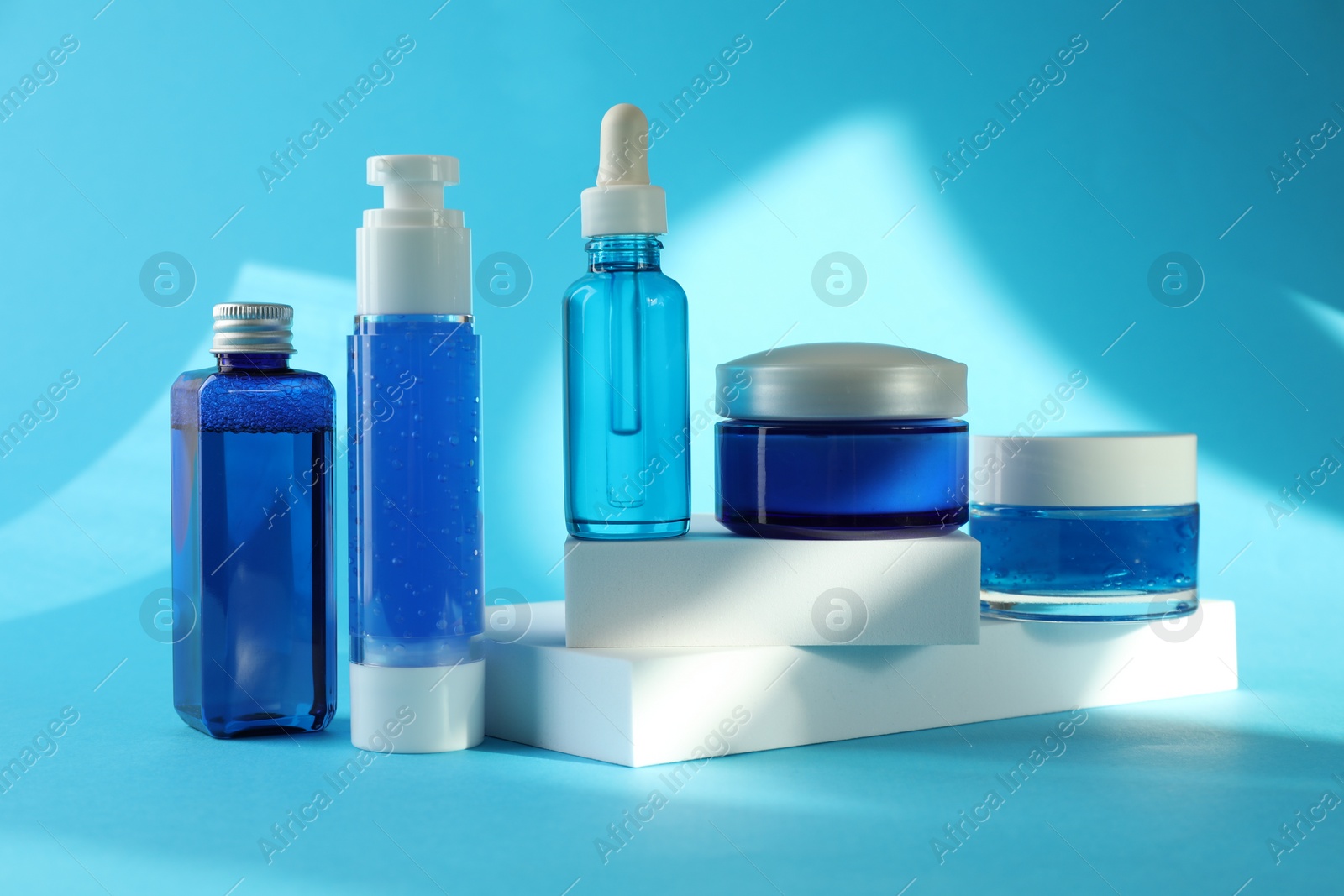 Photo of Set of luxury cosmetic products on light blue background