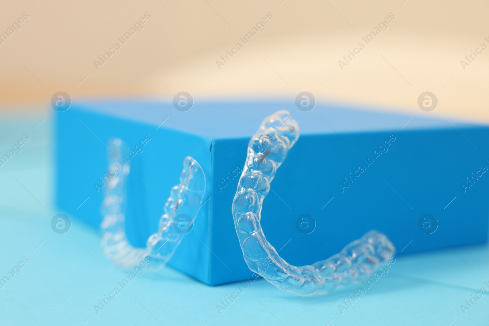 Photo of Transparent dental aligners on color background, closeup