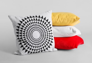 Different stylish soft pillows on grey background