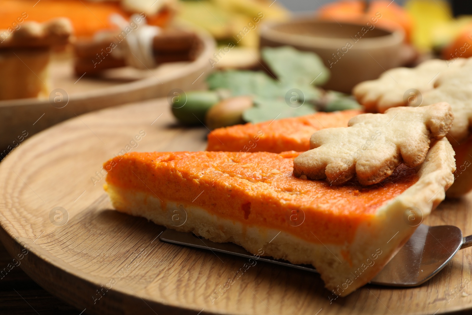 Photo of Slices of delicious homemade pumpkin pie on wooden plate, closeup