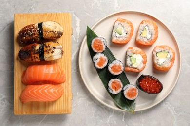 Delicious sushi rolls on white background, flat lay