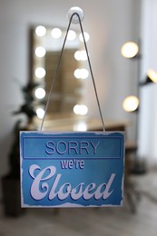 Light blue sign with text Sorry we're Closed hanging on glass door. Coronavirus quarantine