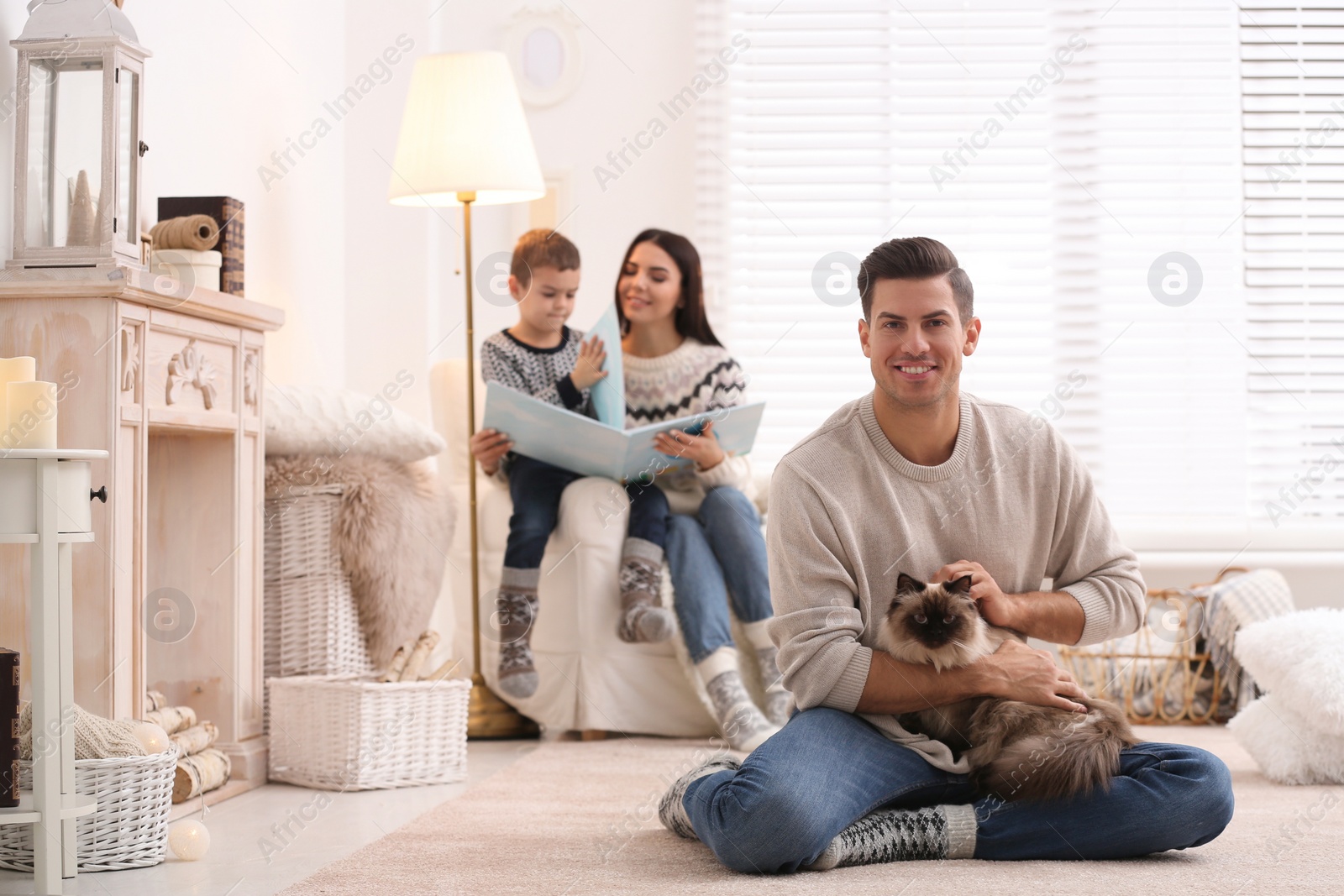 Photo of Father with cat and his family at home. Winter vacation