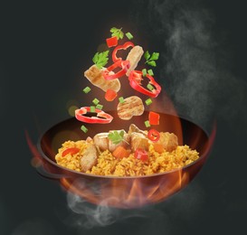 Image of Wok with tasty ingredients and fire on dark background