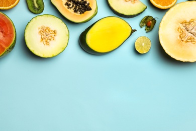 Photo of Flat lay composition with tasty melon and fresh tropical fruits on light blue background, space for text