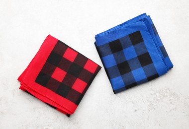 Folded red and blue checkered bandanas on white background, flat lay