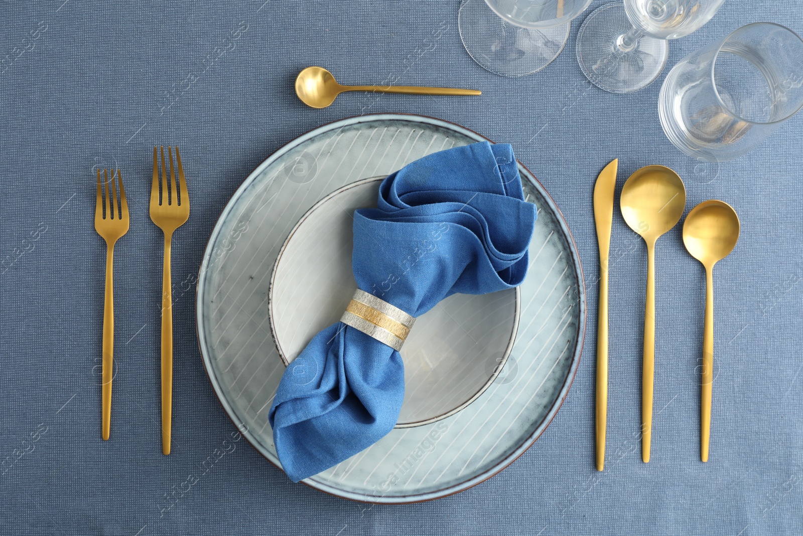 Photo of Stylish setting with cutlery, dishes, napkin and glasses on table, flat lay