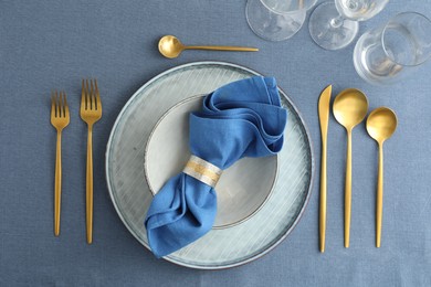 Stylish setting with cutlery, dishes, napkin and glasses on table, flat lay