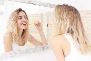 Young woman brushing her teeth in bathroom