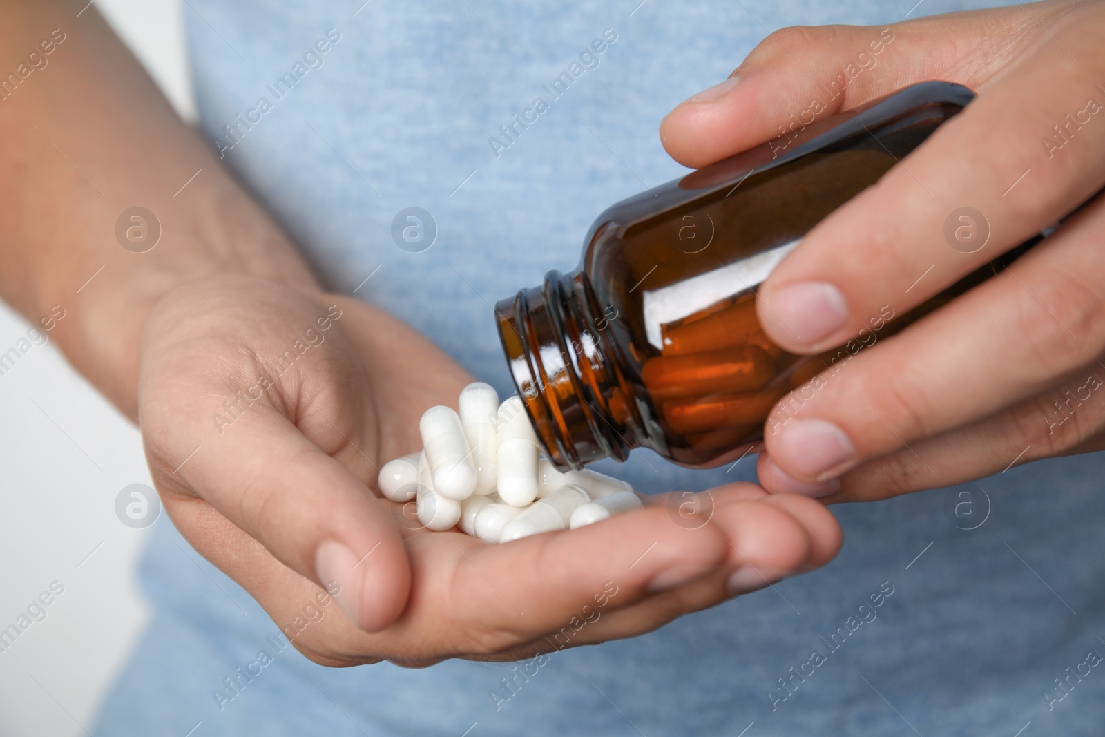 Photo of Man with amino acids pills on light background, closeup