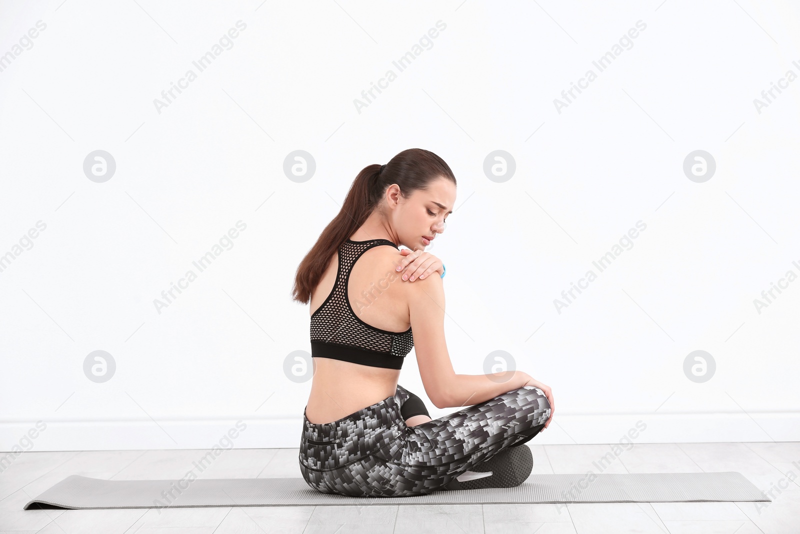 Photo of Female athlete suffering from shoulder pain during training indoors