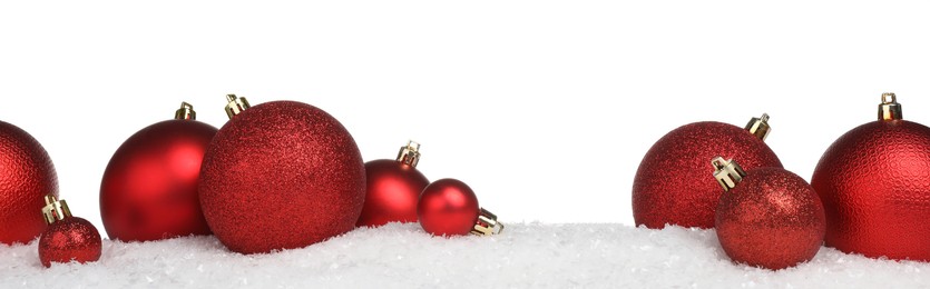 Photo of Beautiful red Christmas balls on snow against white background