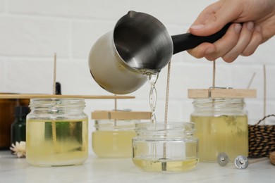 Woman making candles at white table, closeup