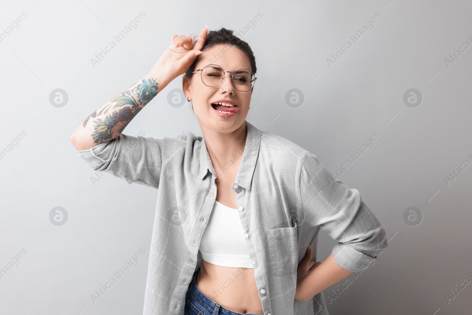 Photo of Portrait of beautiful tattooed woman on gray background