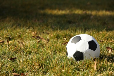 Photo of Soccer ball on green grass outdoors, space for text