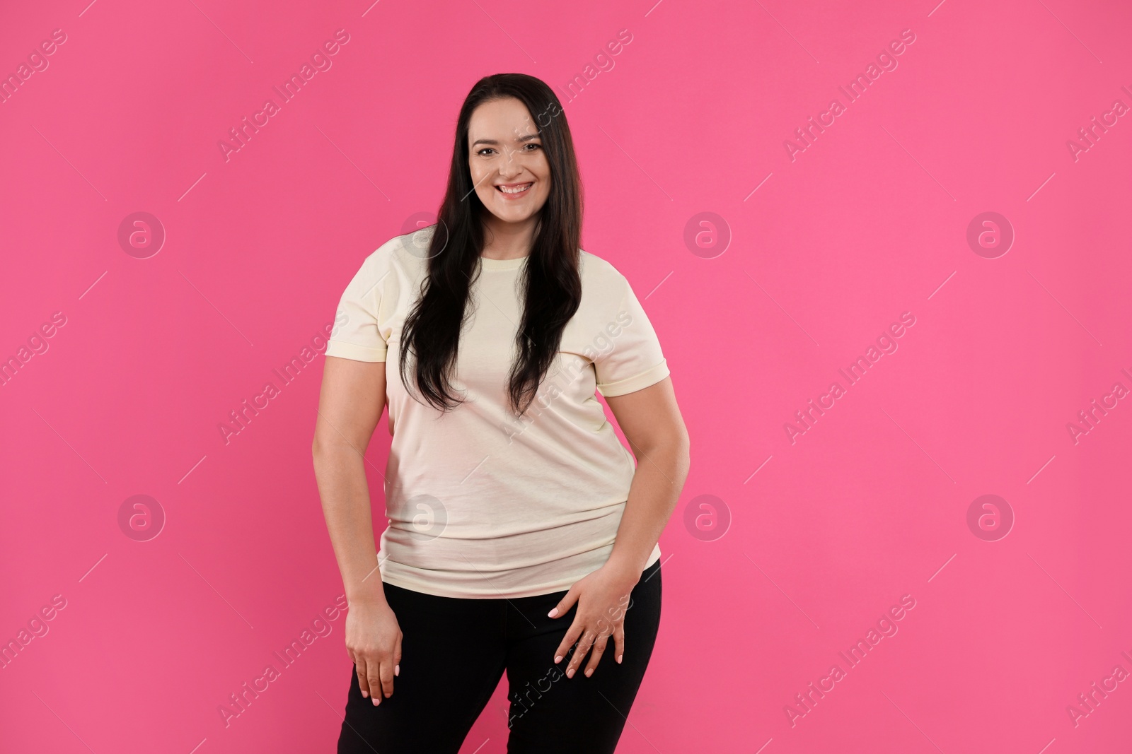 Photo of Beautiful overweight woman with charming smile on pink background