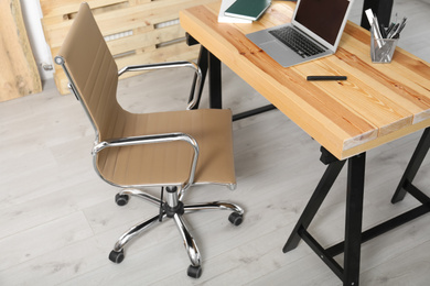 Comfortable workplace with office chair and wooden table