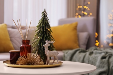 Photo of Composition with decorative Christmas tree and reindeer on white table in living room, space for text