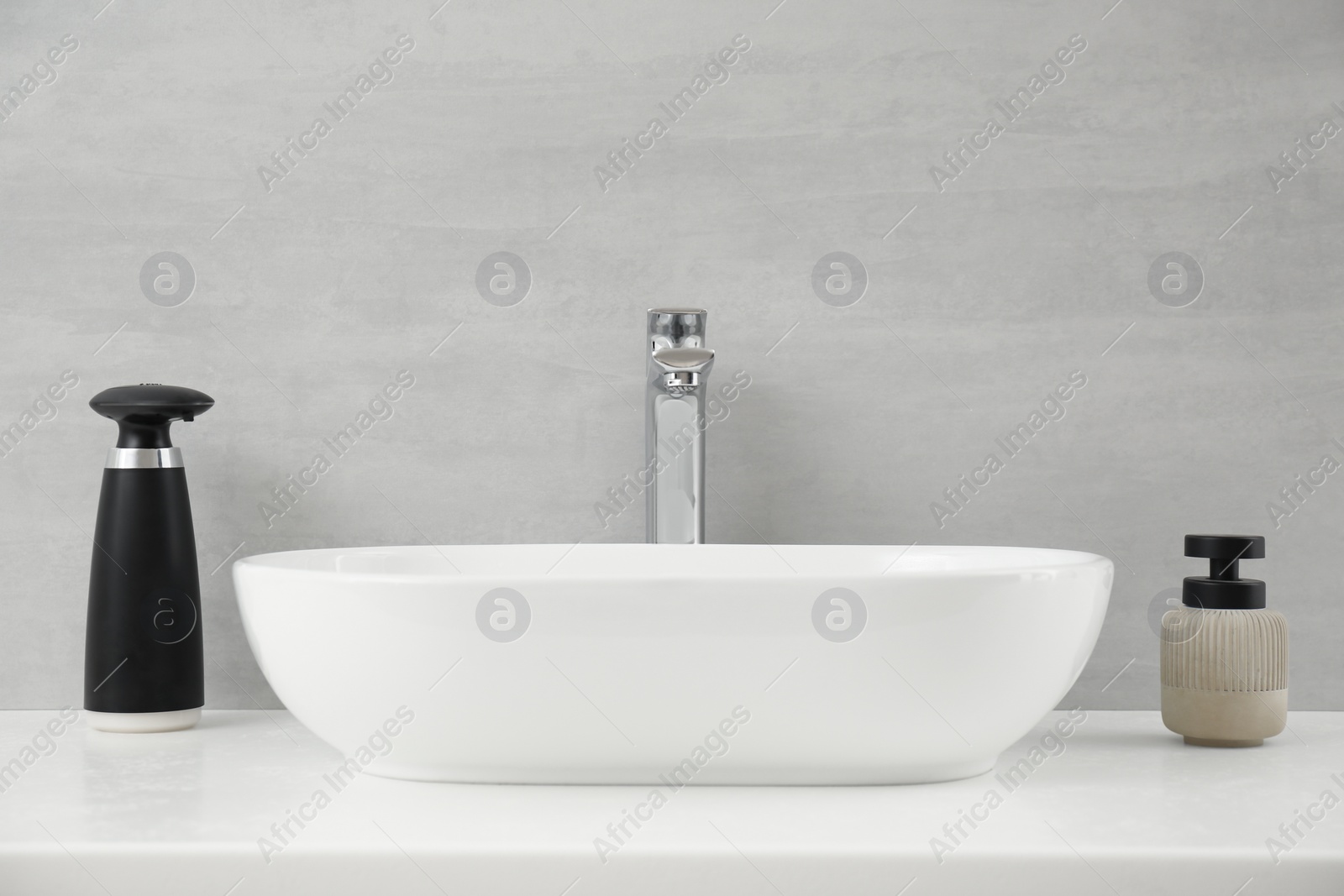 Photo of Modern automatic soap dispenser near sink in bathroom