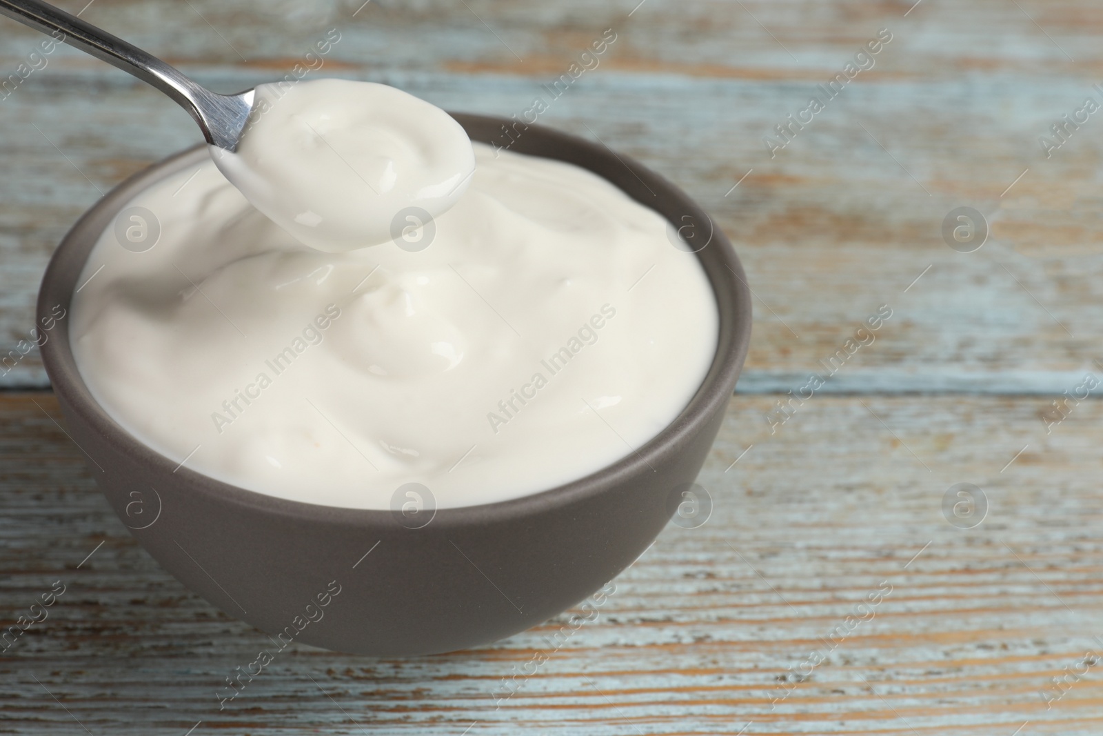 Photo of Ceramic bowl with delicious organic yogurt on wooden table, closeup