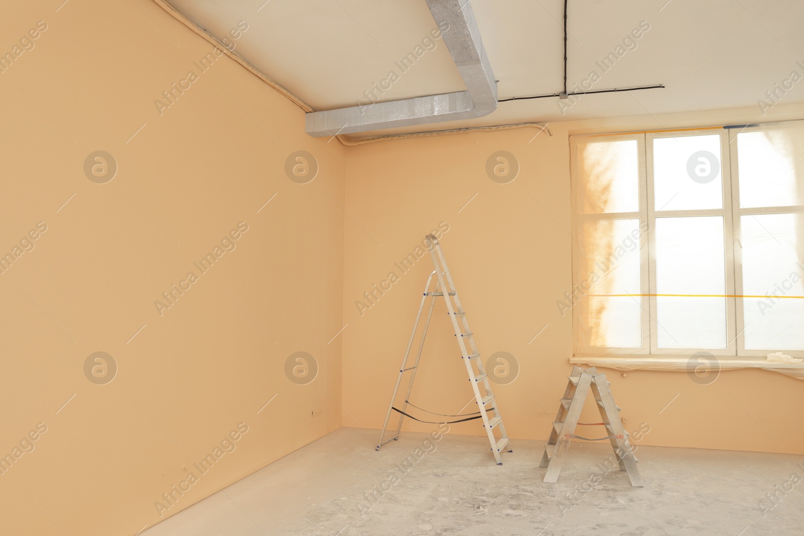 Photo of Room with pale orange walls and windows prepared for renovation