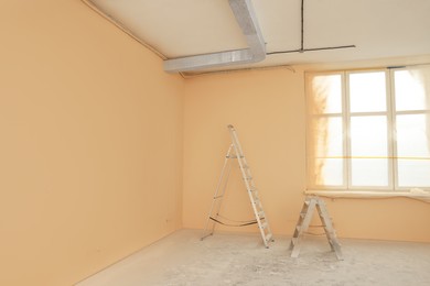 Photo of Room with pale orange walls and windows prepared for renovation