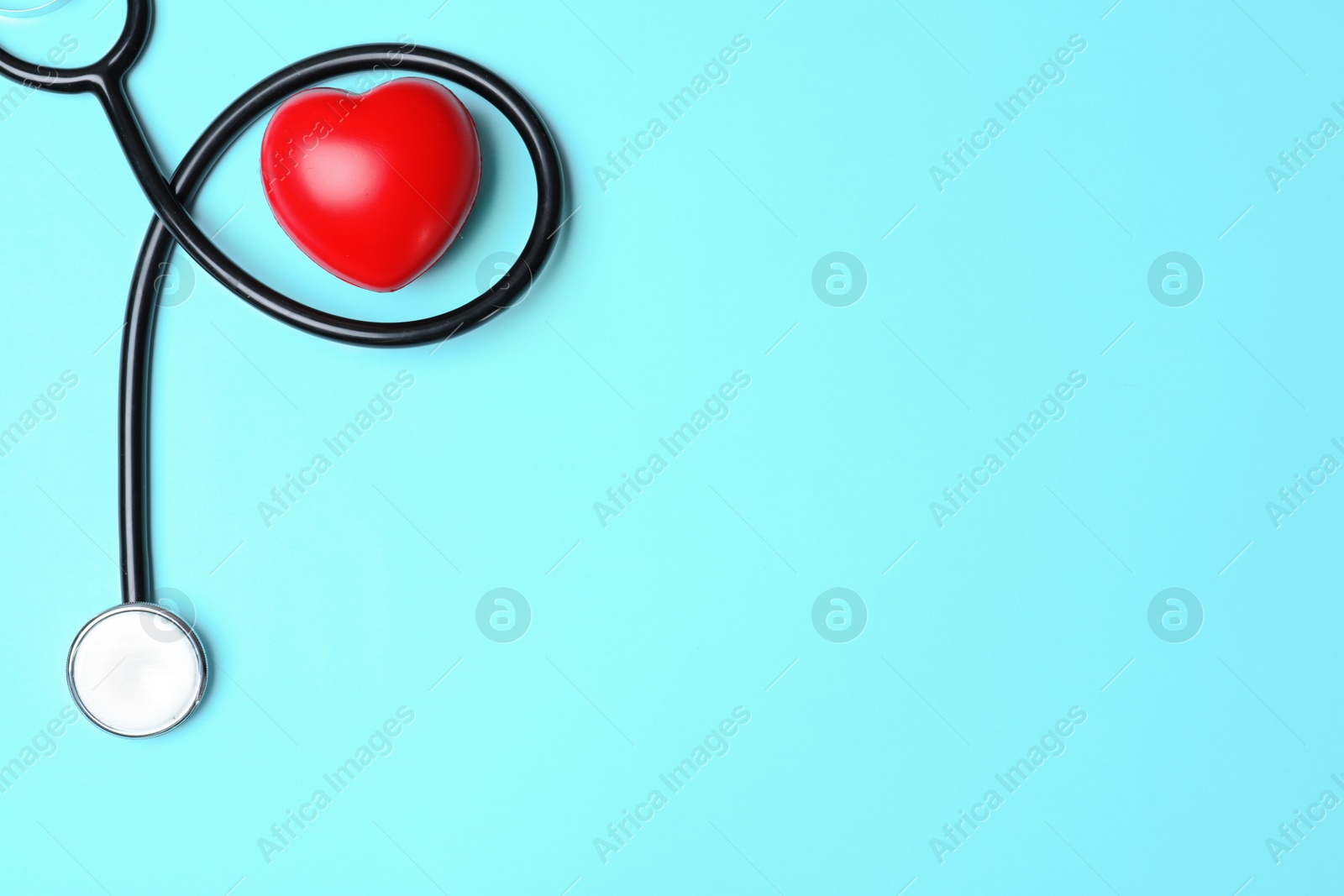 Photo of Stethoscope with red heart and space for text on blue background, flat lay