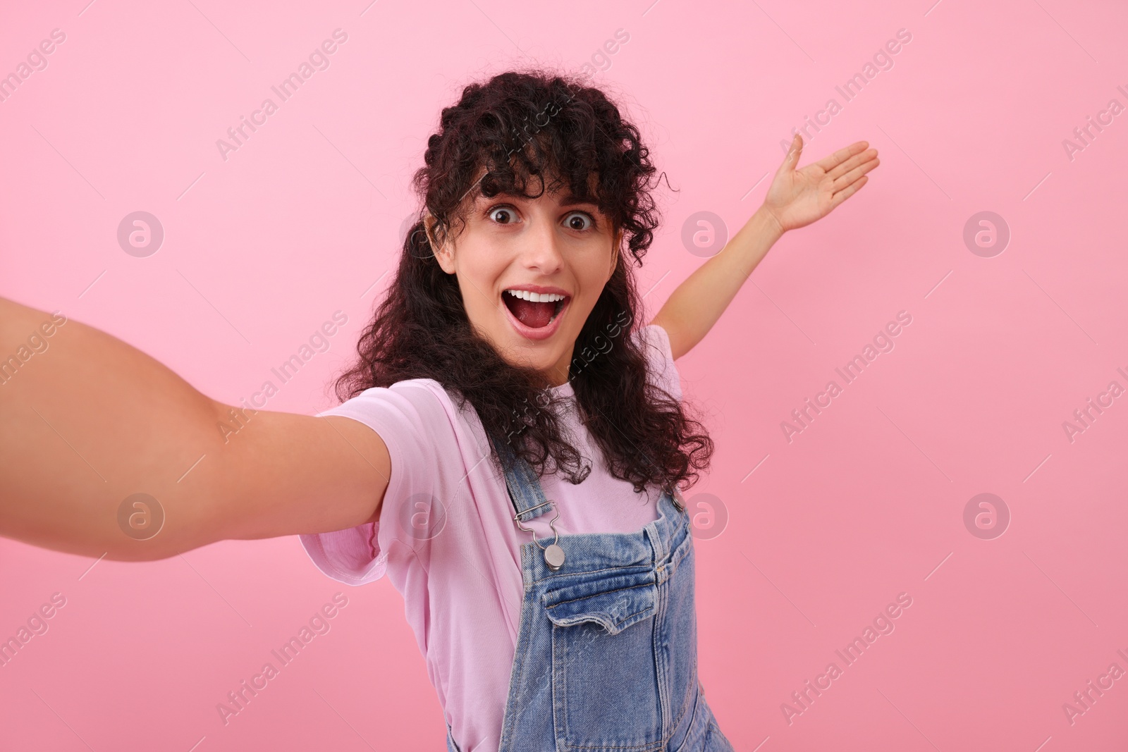 Photo of Beautiful woman taking selfie on pink background