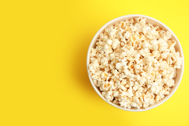 Tasty pop corn on yellow background, top view. Space for text