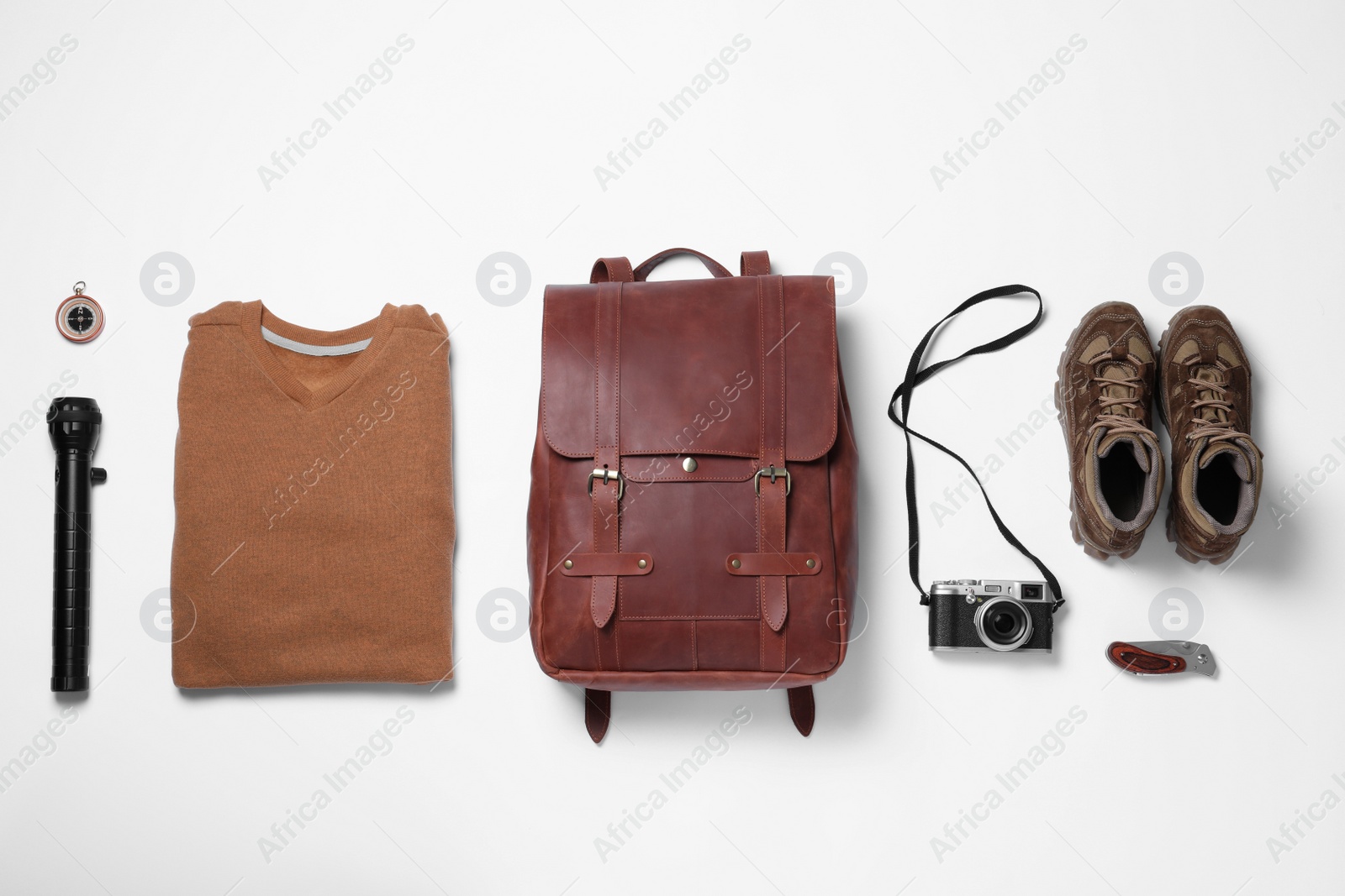 Photo of Composition with leather backpack and camping equipment for tourist on white background, flat lay