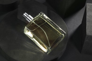 Photo of Stylish presentation of luxury men`s perfume in bottle on black background