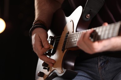 Photo of Man playing electric guitar on stage, closeup. Rock concert