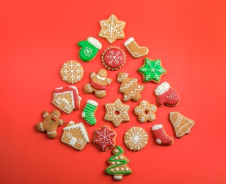 Photo of Christmas tree shape made of tasty homemade cookies on color background, top view