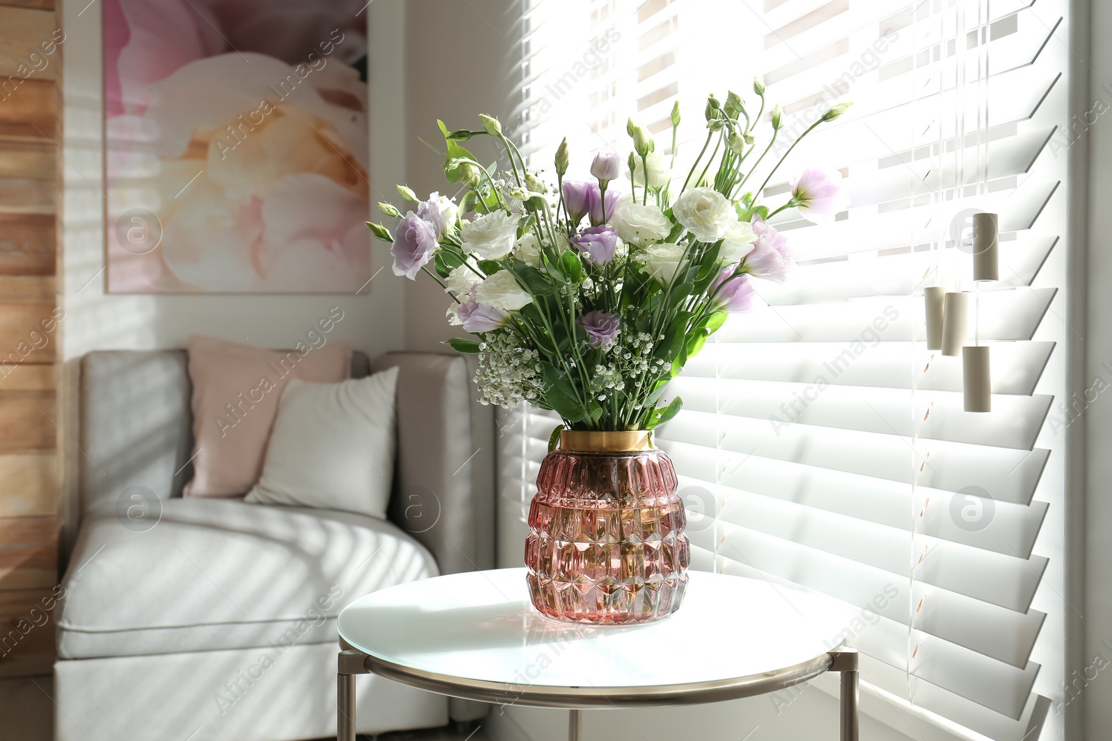 Photo of Bouquet of beautiful Eustoma flowers on table in room. Space for text