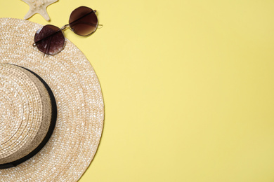 Photo of Hat, sunglasses and starfish on yellow background, flat lay with space for text. Beach objects