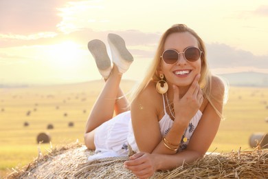 Photo of Beautiful hippie woman on hay bale in field