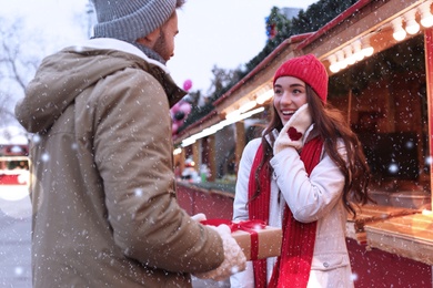 Image of Lovely couple with Christmas present at winter fair