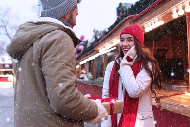 Lovely couple with Christmas present at winter fair