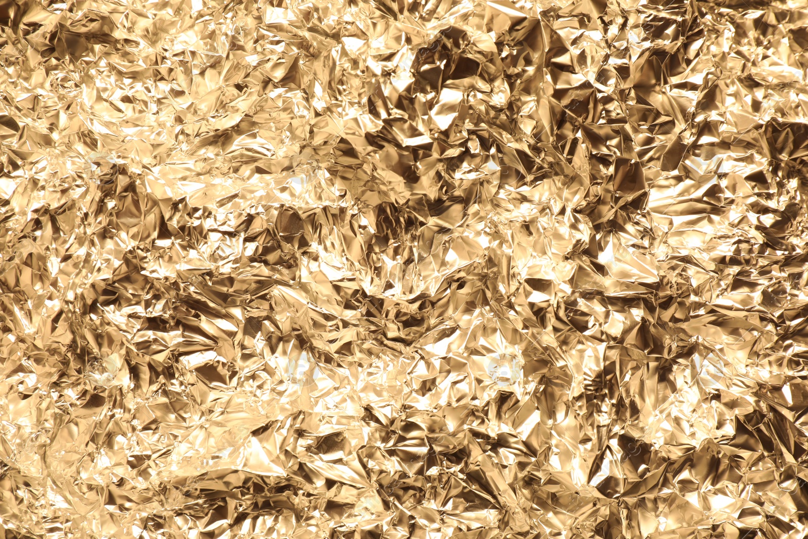 Photo of Crumpled gold foil as background, top view