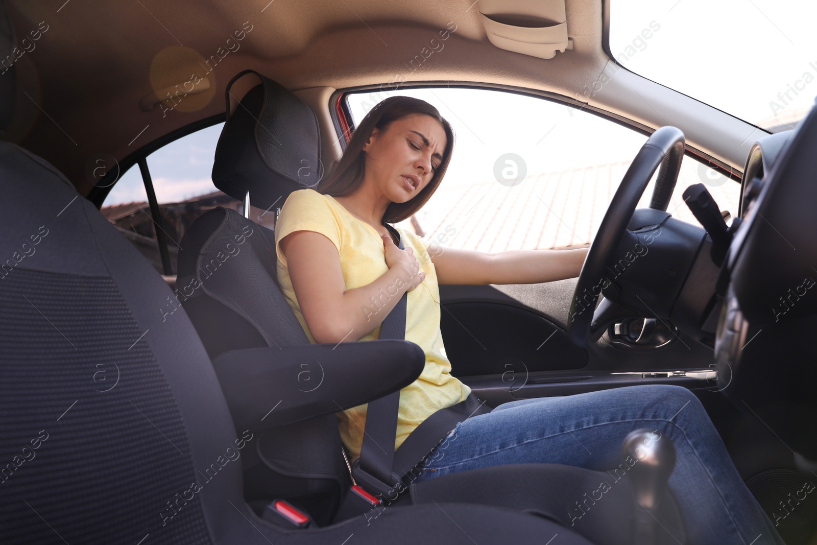 Photo of Young woman suffering from heart attack in car