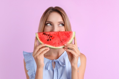 Photo of Pretty young woman with juicy watermelon on color background