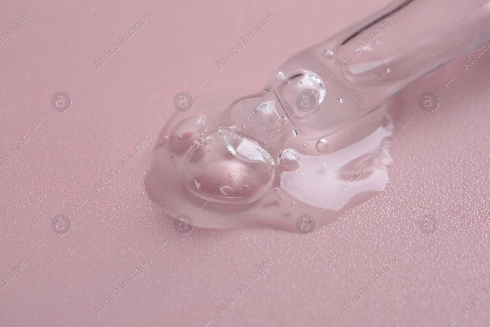 Photo of Pipette with cosmetic serum on pink background, closeup