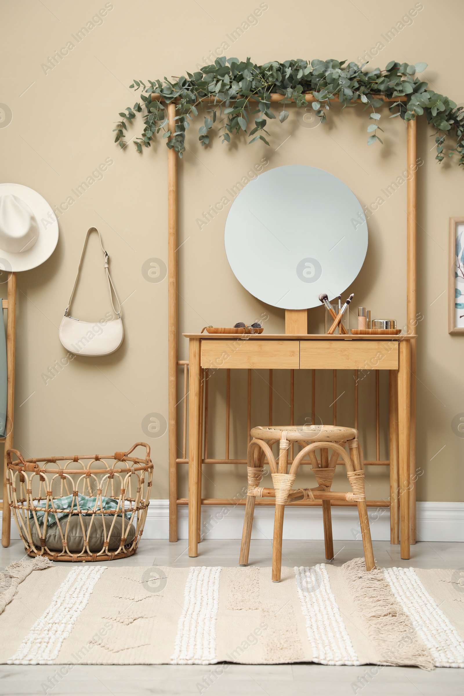 Photo of Stylish room decorated with beautiful eucalyptus garland on dressing table