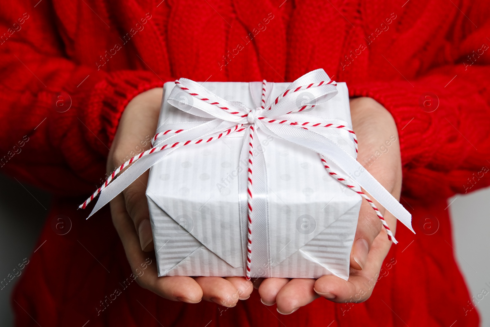 Photo of Woman holding white Christmas gift box, closeup