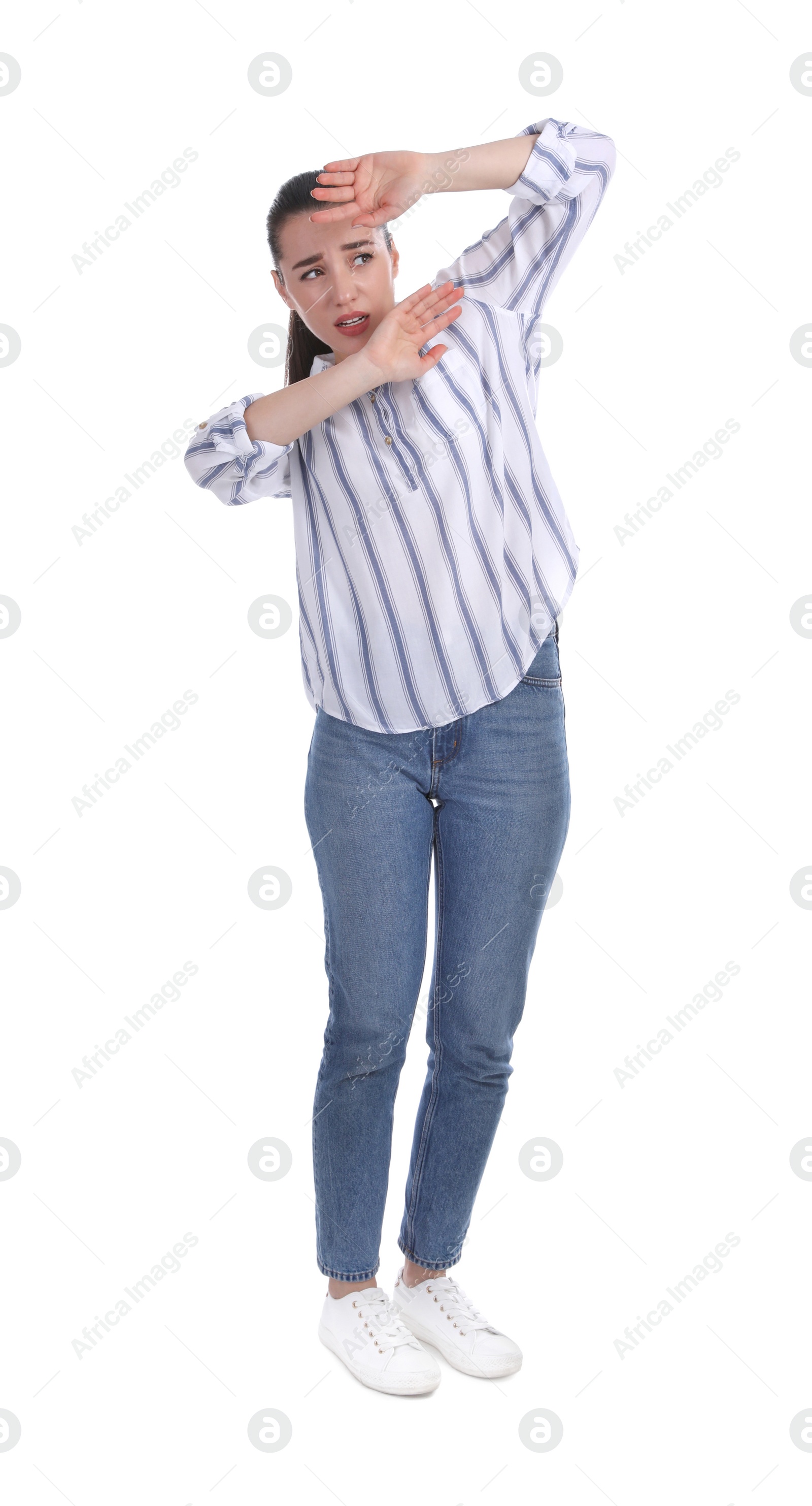Photo of Scared woman holding hands in defensive manner on white background