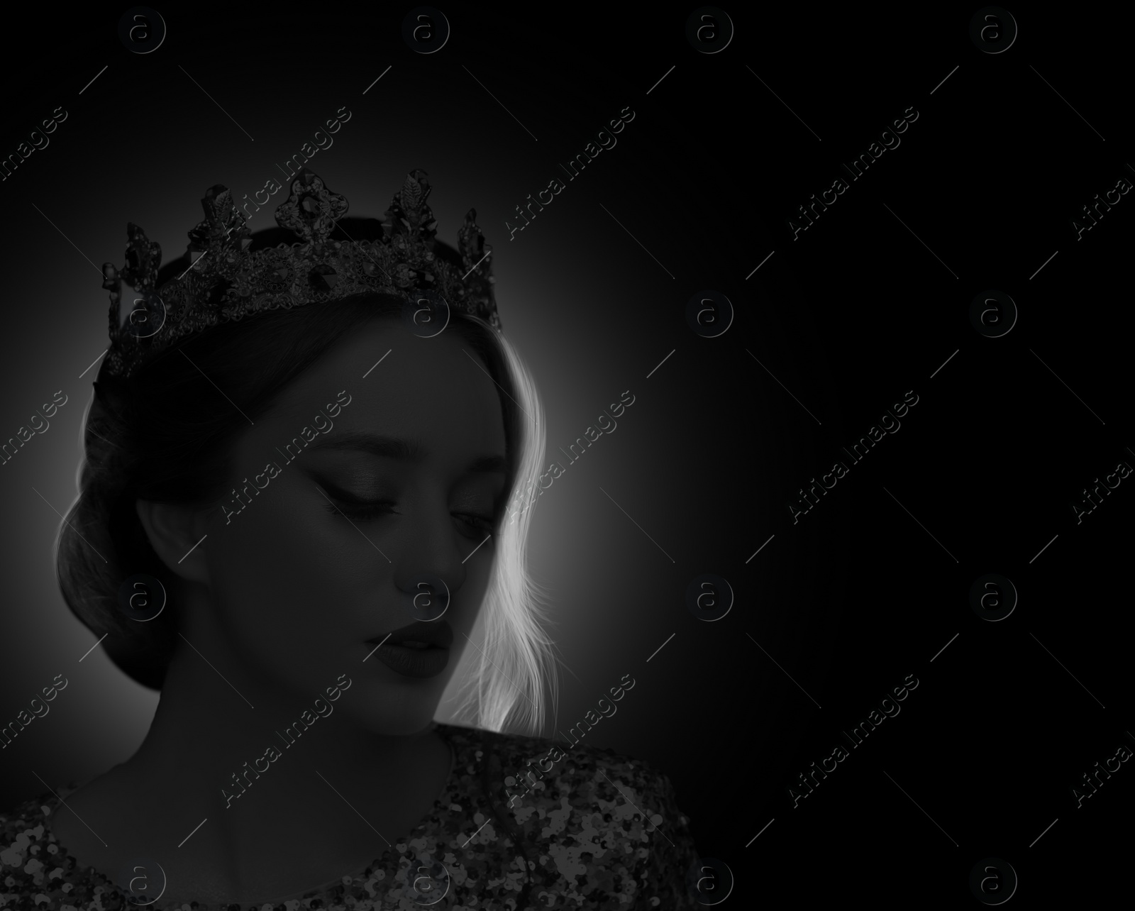 Image of Silhouette of woman with crown in darkness. Portrait on black background