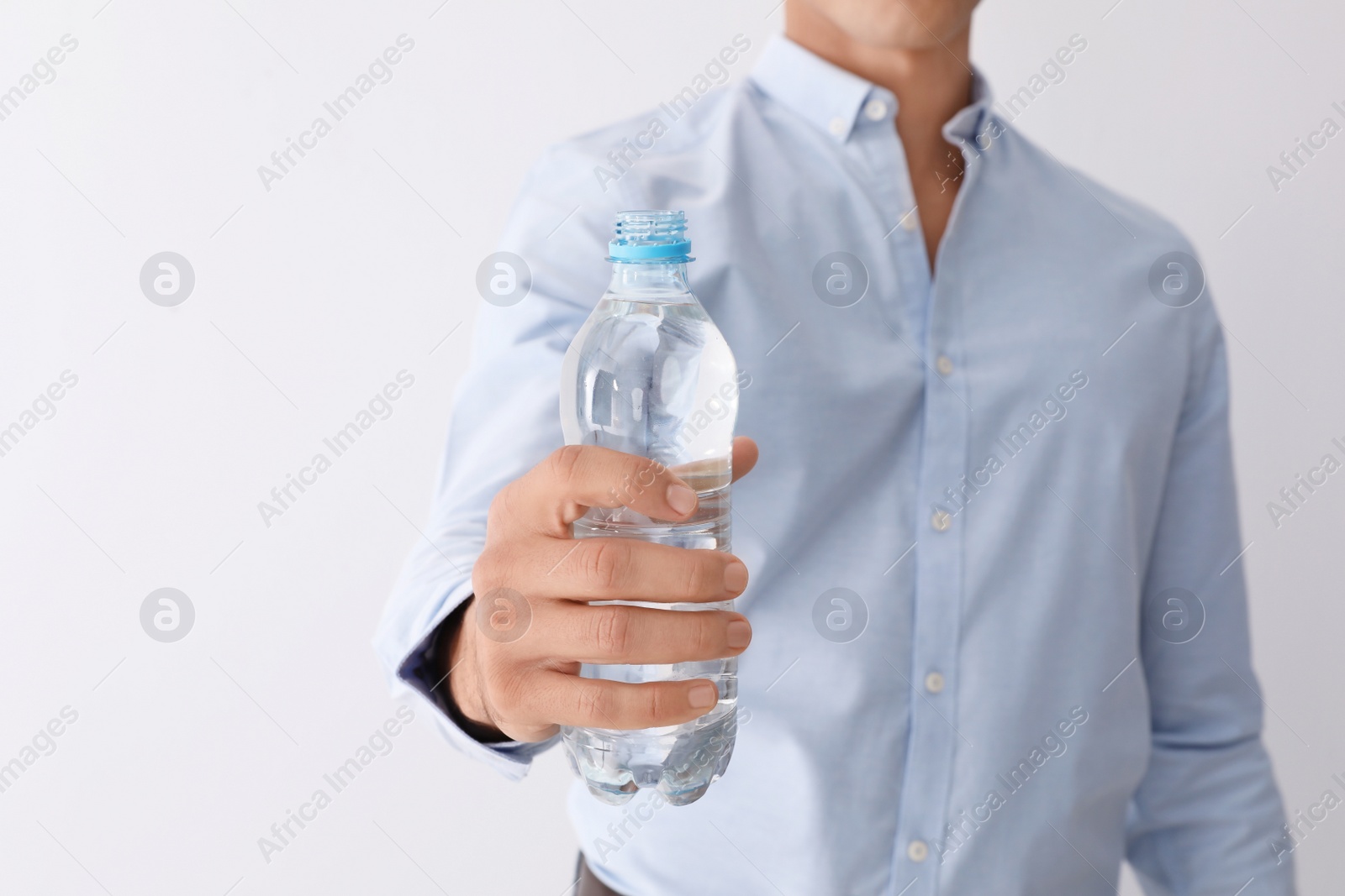 Photo of Man holding bottle of pure water on white background, closeup