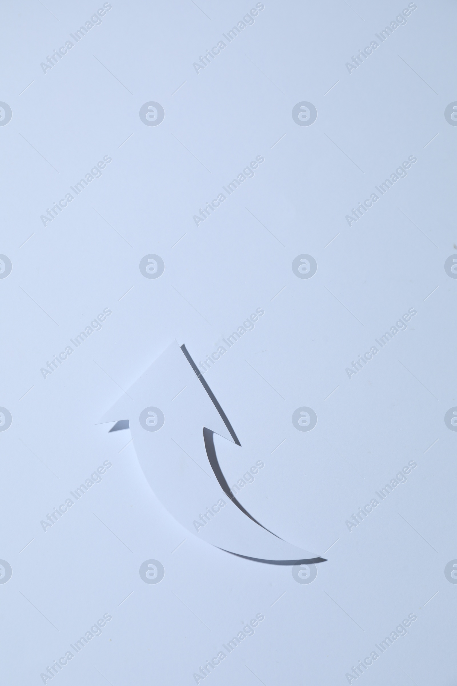 Photo of Curved paper arrow on white background, top view. Space for text