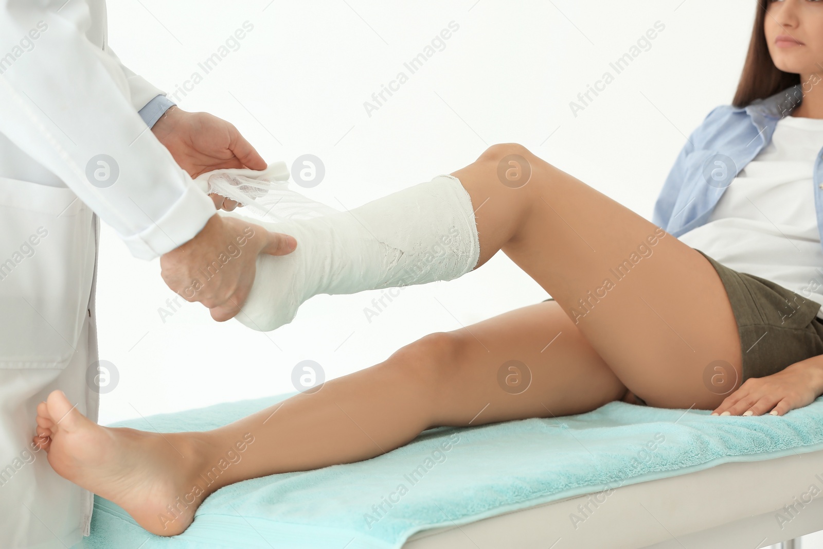 Photo of Doctor putting patient's leg in plaster  at clinic